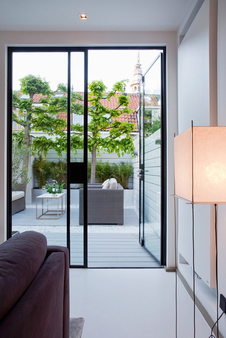 Blick vom Wohnzimmer auf moderne Terrasse mit Sofa