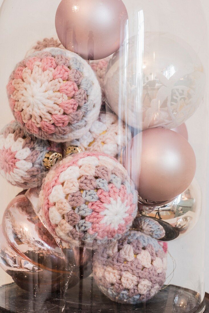 Vintage-Weihnachtskugeln mit umhäkelten Weihnachtskugeln in Pastelltönen unter Glashaube