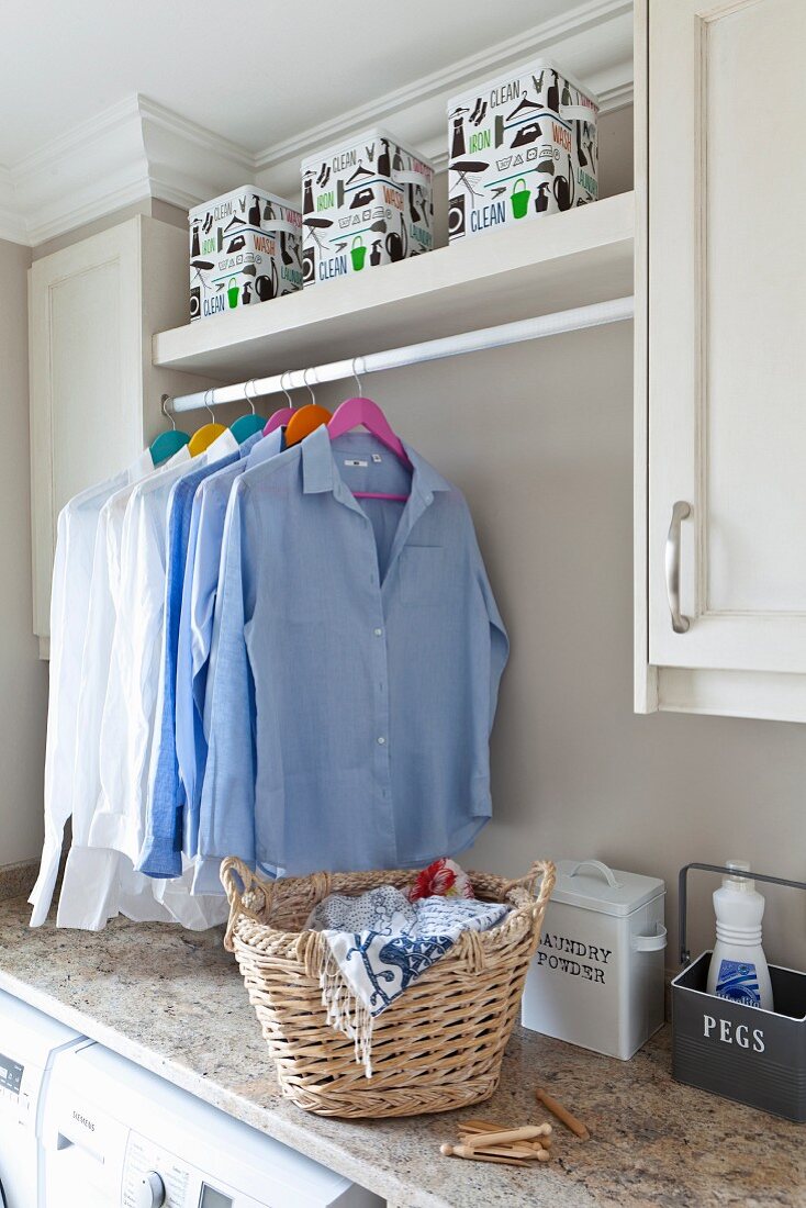 Clothes rack between wall units in laundry room
