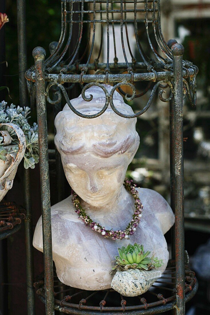 Stone bust of woman and sempervivum on plant stand