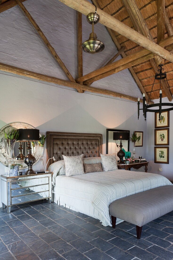 Doppelbett mit gepolstertem Kopfteil im eleganten Vintage Schlafzimmer mit sichtbarer Dachkonstruktion