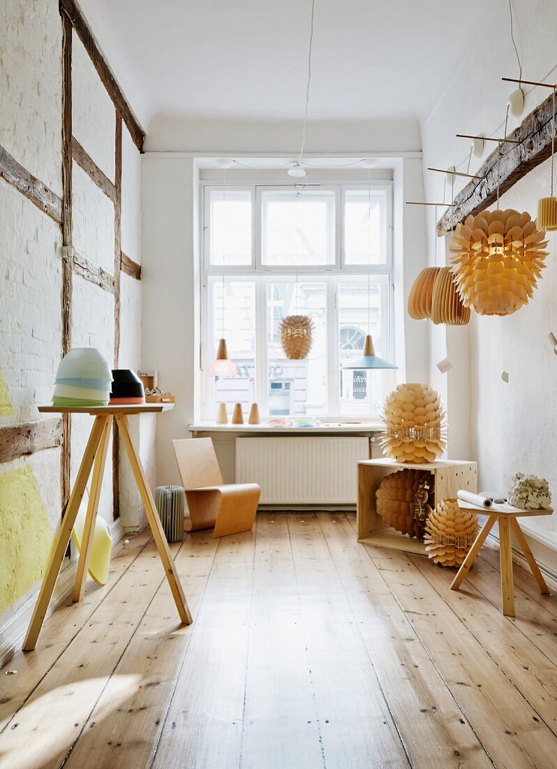Lampshades made from wooden scales in rustic showroom of lamp-maker with pristine wooden floor