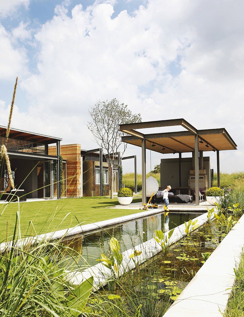 Gartenanlage mit Wasserbecken und Gartenpavillon mit Stahlträgern