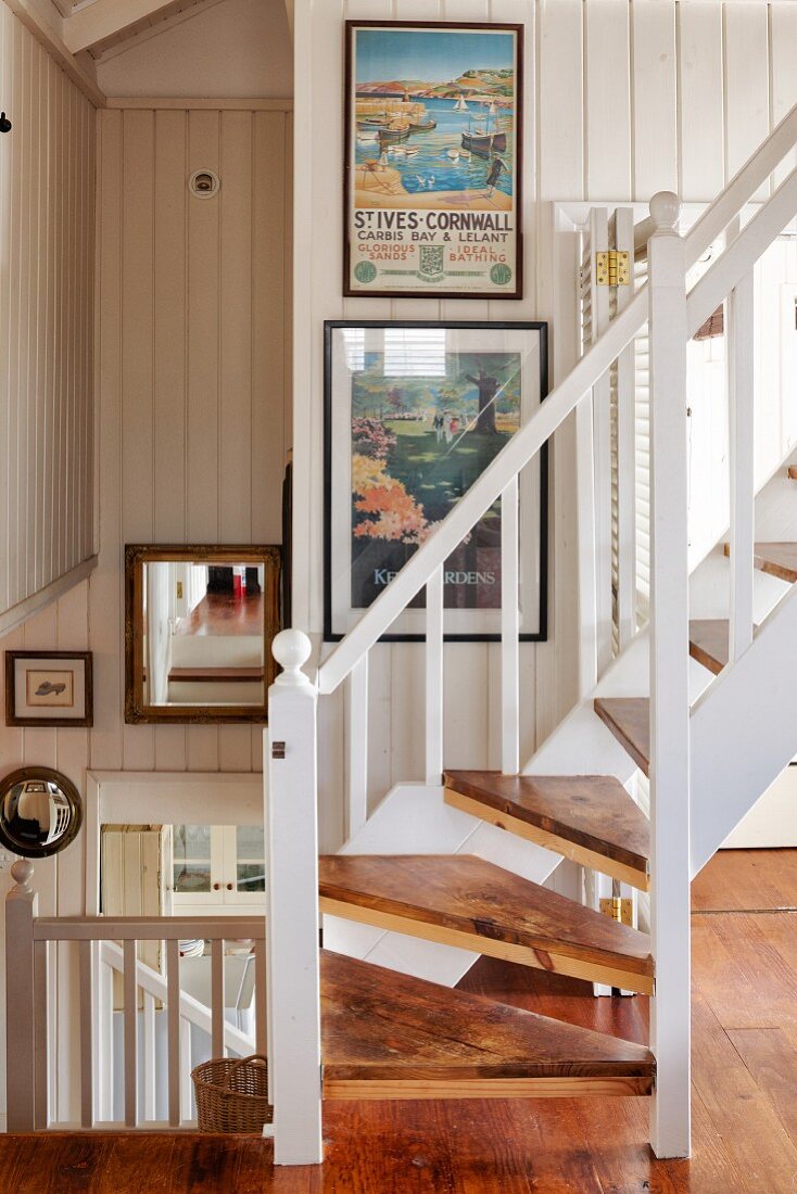 Holztreppe mit weißem Geländer in offenem Treppenhaus eines Strandhauses