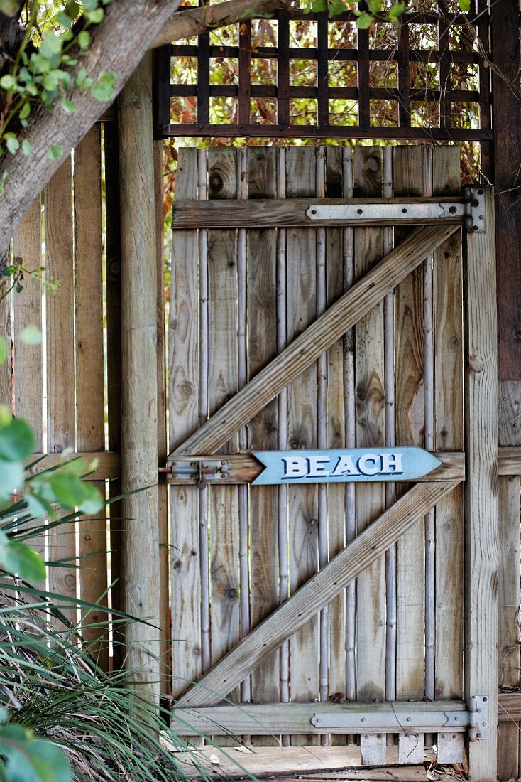 Rustic, weathered wooden gate with sign