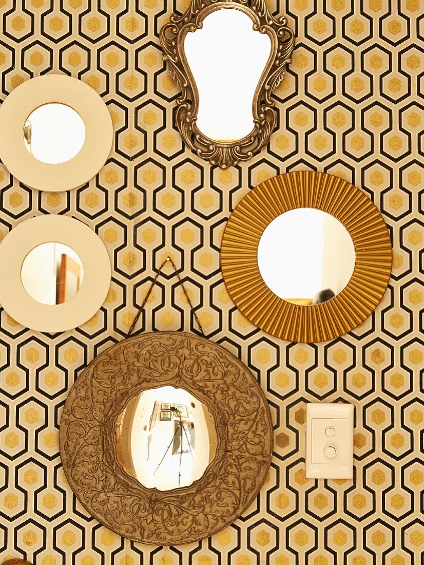 Collection of mirrors on retro wallpaper with black and yellow graphic pattern
