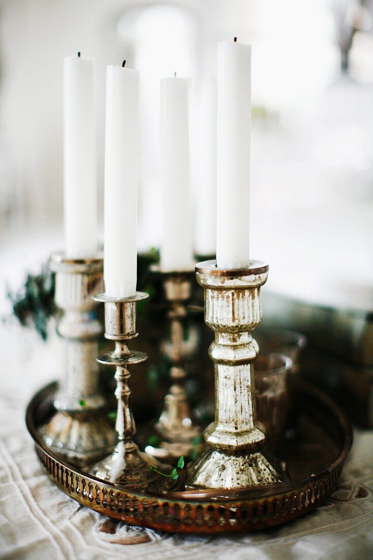 Kerzenhalter in Silber mit weissen Kerzen auf Vintage Tablett
