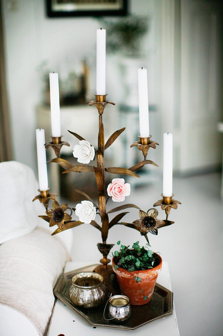 Messing Kerzenhalter mit farbigen Deko Rosen und weissen Kerzen, auf Tablett zwischen Pflanzentopf und Silber Döschen