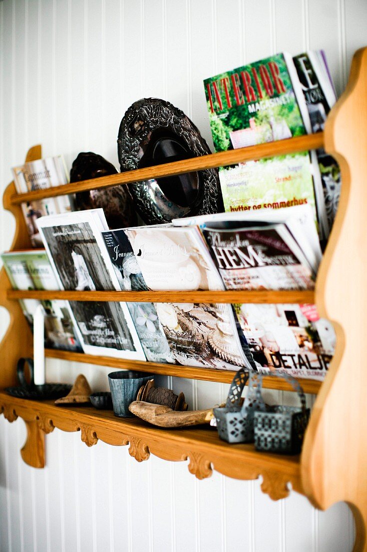 Geschnitztes Holz Wandbord mit Zeitschriften an weisser Holzwand