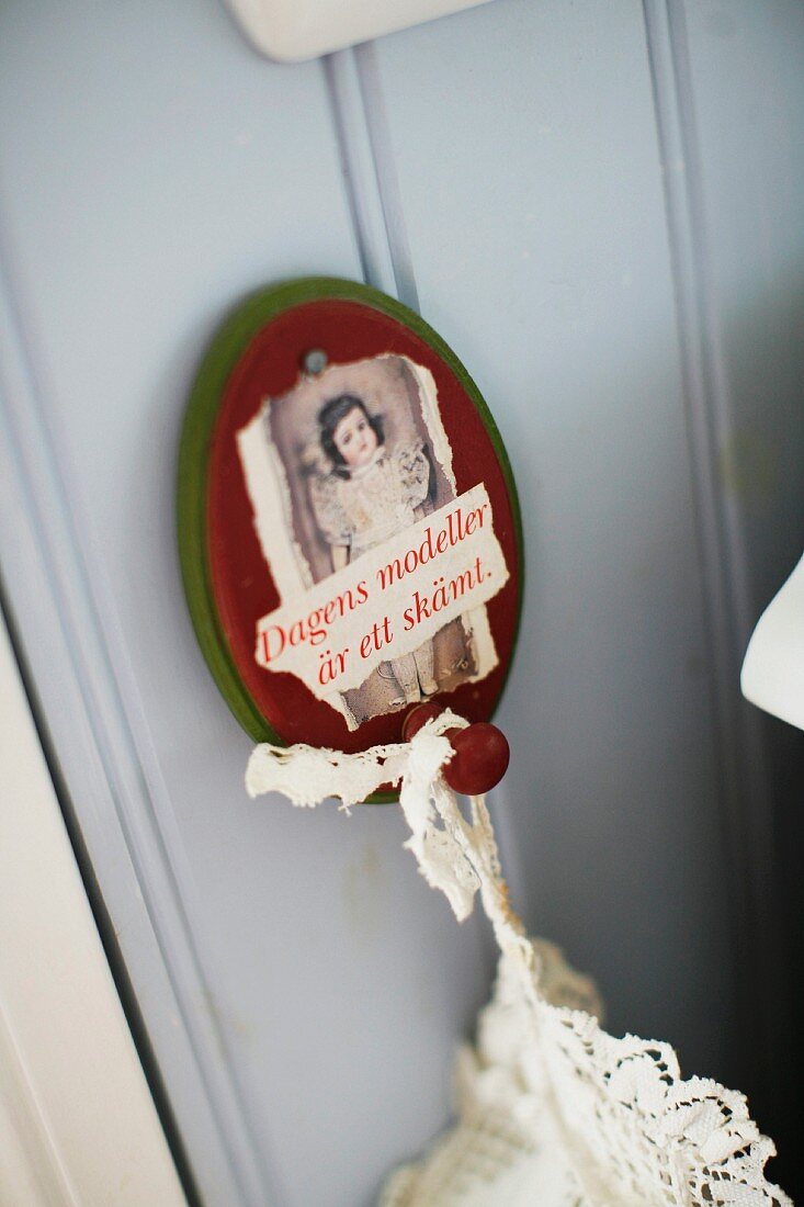 Vintage arrangement of lace textile hanging from painted, wooden wall hook