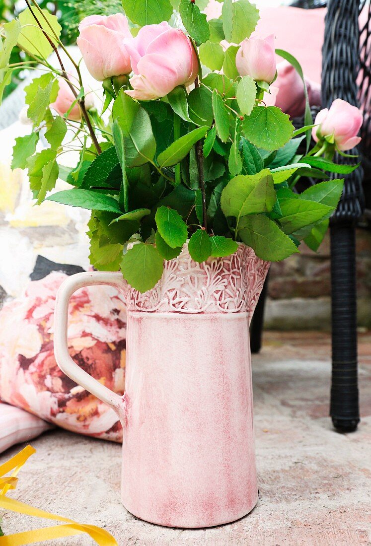 Pink roses in ornate jug