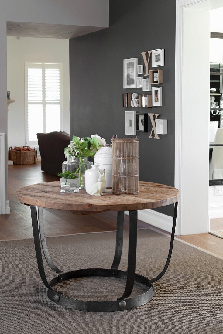 Tisch mit Holzplatte auf Metallgestell im Vorraum, im Hintergrund offene Tür und Blick in Wohnraum