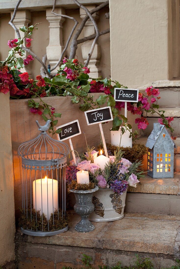 Weihnachtlich dekorierte Steinstufen mit brennenden Kerzen in Laterne und Blumengesteck