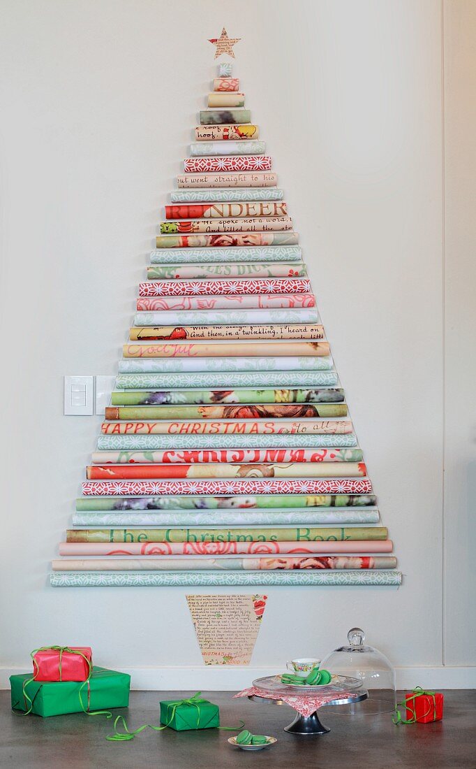 Stilisierter Weihnachtsbaum aus verschieden gemusterten Papierrollen an der Wand