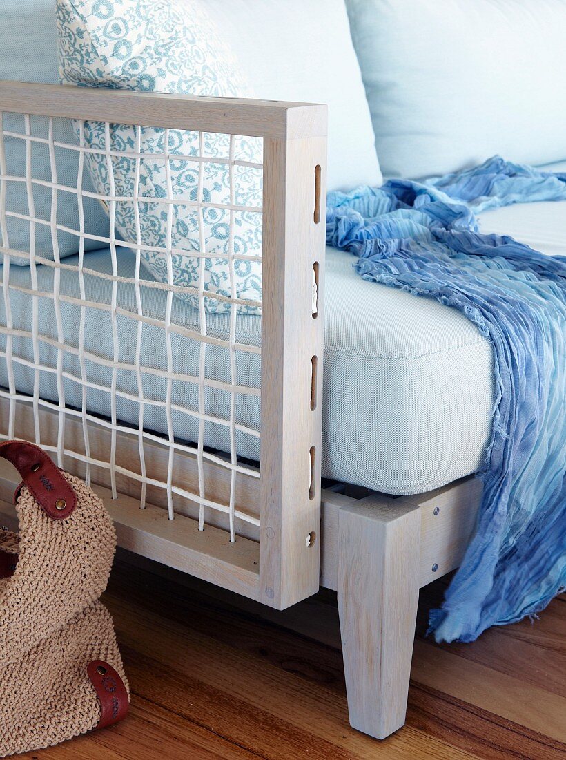 Designer sofa with wooden lattice frame and blue scarf on seat