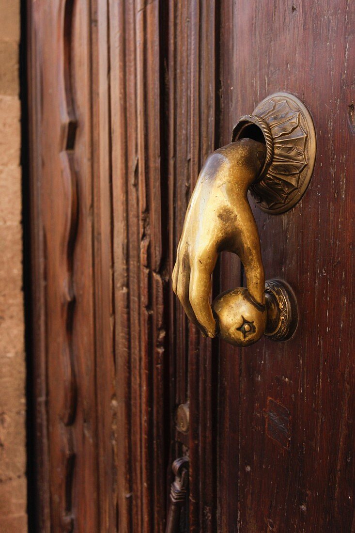 Alte Haustür mit Messinggriff in Form einer Hand mit rundem Knauf in San Miguel de Allende (Mexiko)