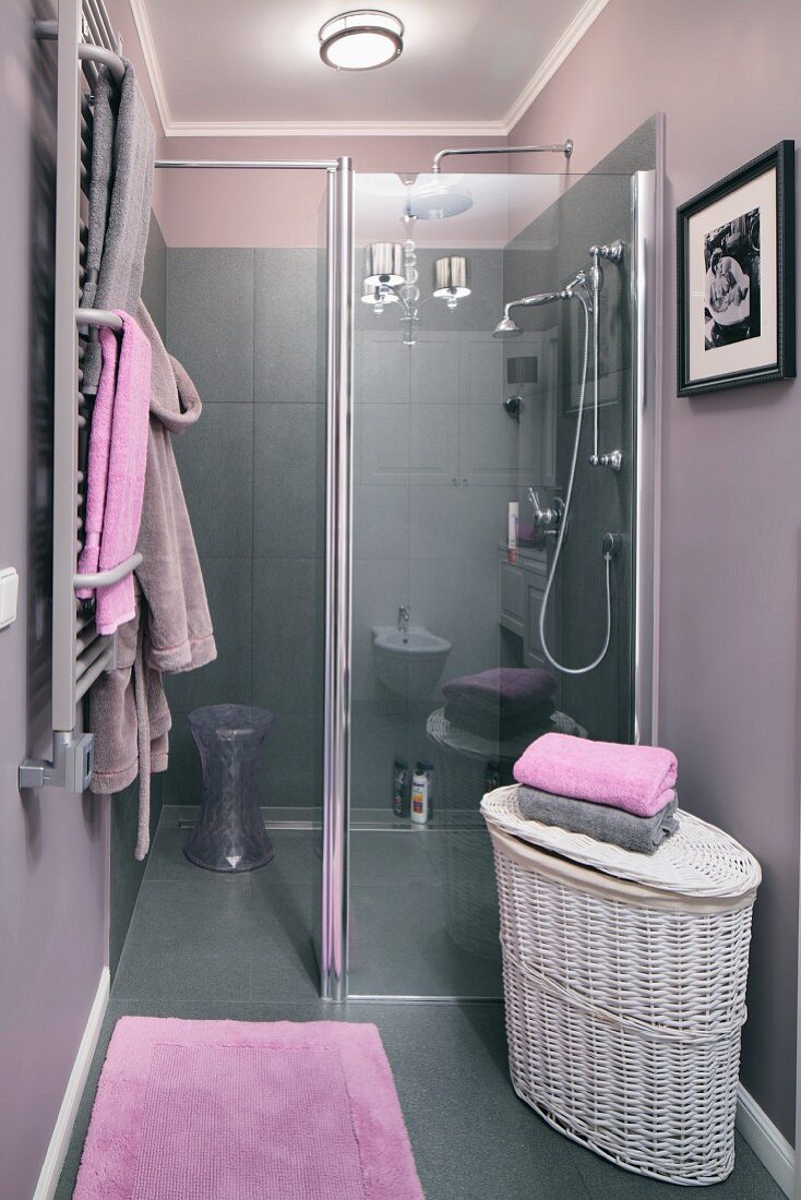 Offene Dusche in elegantem Bad mit grauen Fliesen, Wandfarbe in grauviolett und fliederfarbenen Handtüchern