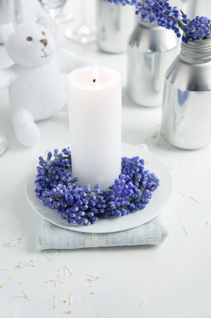 White candle with wreath of grape hyacinths