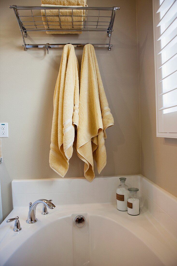 Bathroom with towels hanging over bathtub; San Marcos; California; USA