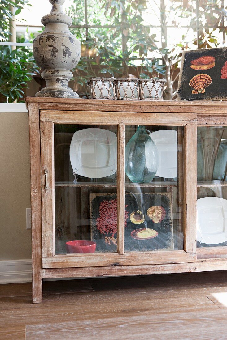 Sideboard für Geschirr und Dekoobjekt mit Glastüren unter Fenster in Wohnraum