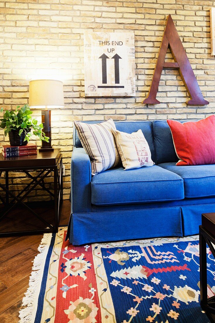 Wohnzimmer mit blauem Sofa, Beistelltisch & gemustertem Teppich