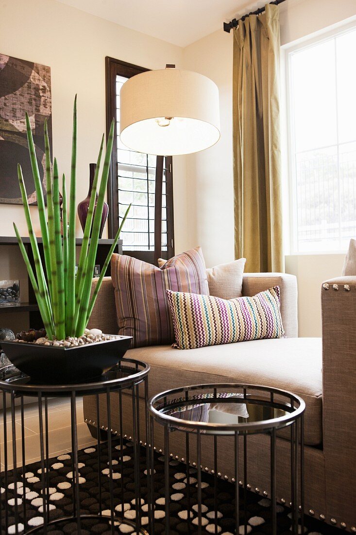Wohnzimmer mit Chaiselongue, Stehlampe & Zimmerpflanze auf Beistelltischchen