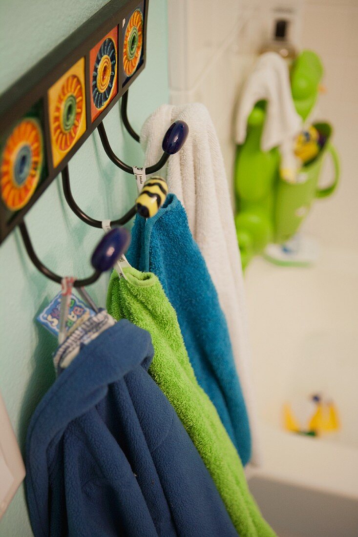 Close-up of towels hanging on hooks in bathroom
