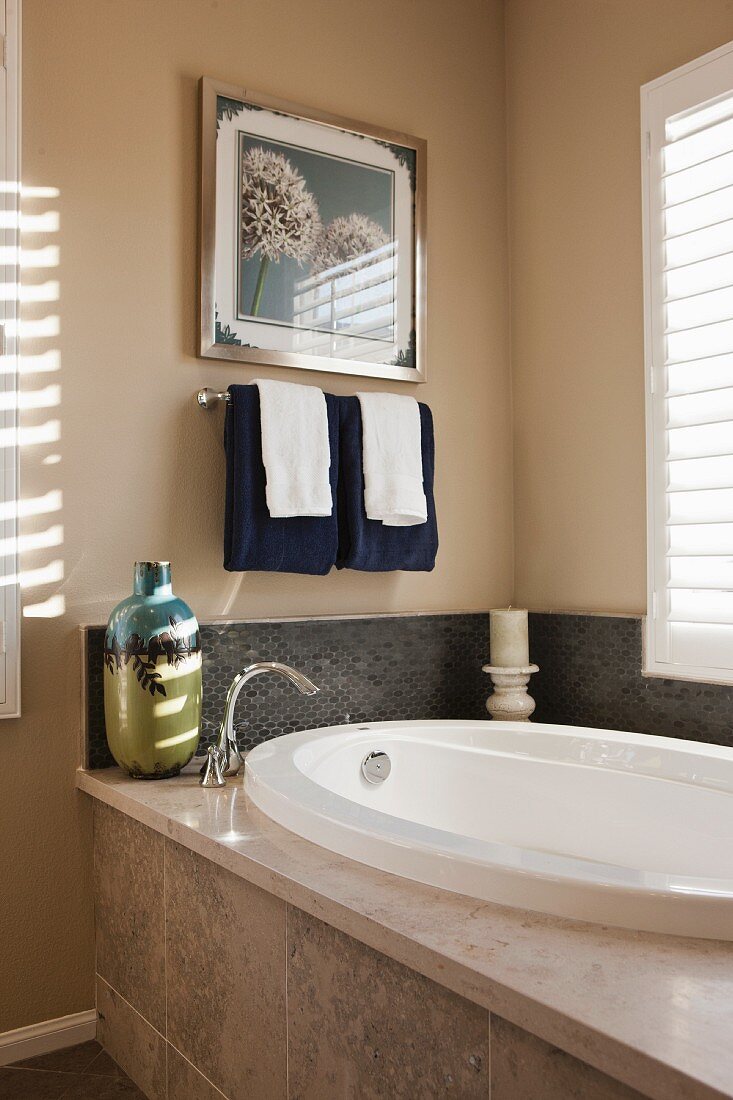 Ovale Badewanne in Badezimmerecke mit Lamellenfenster