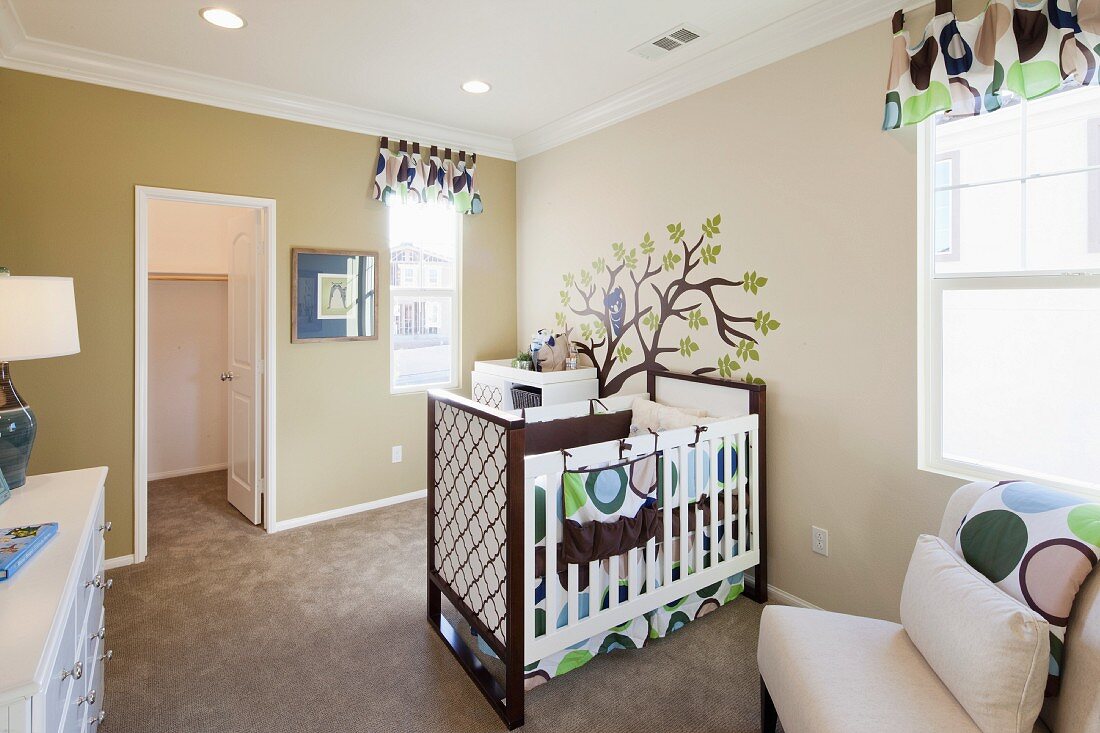 Babyschlafzimmer mit Gitterbett, Sessel & Wandmalerei