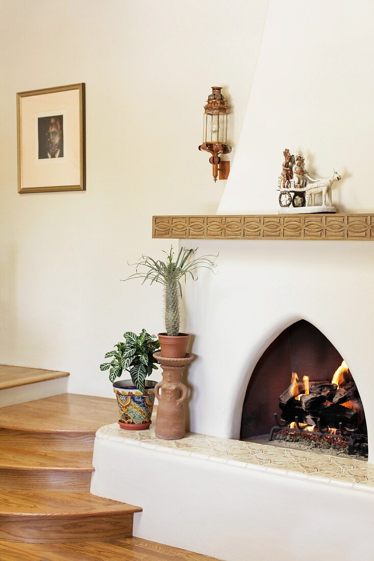 Fire in fireplace next to wooden stairs; Santa Fe; New Mexico; USA