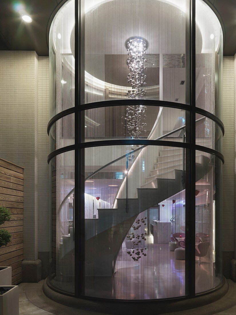 Verglaste Wendeltreppe eines Luxushotels mit Dekoobjekt aus Kugeln