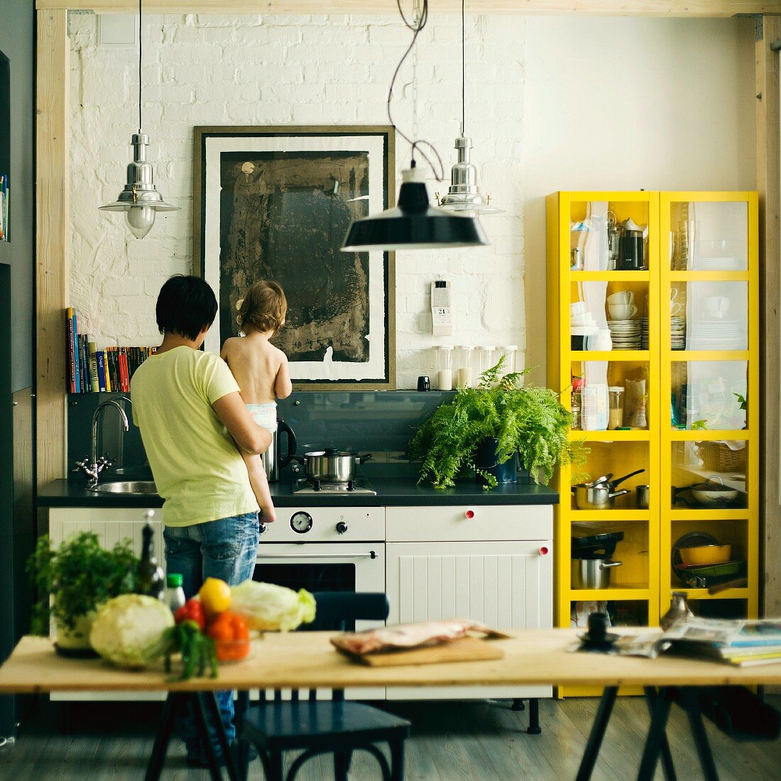 Father holding son in kitchen