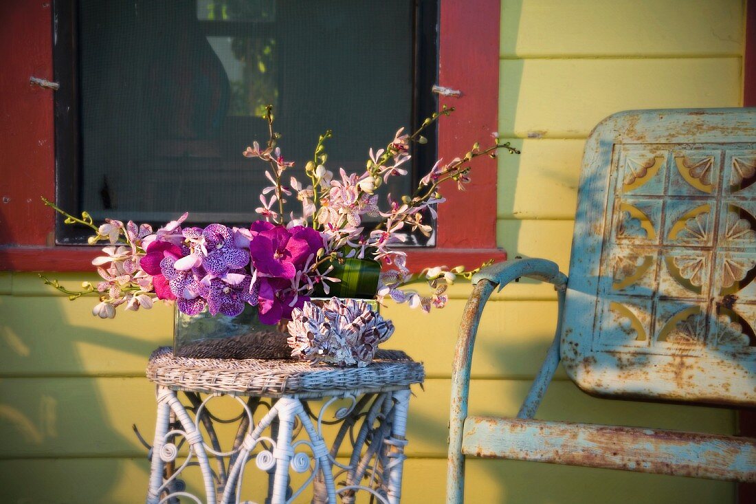 Rustic chair by flower arrangement on table on porch