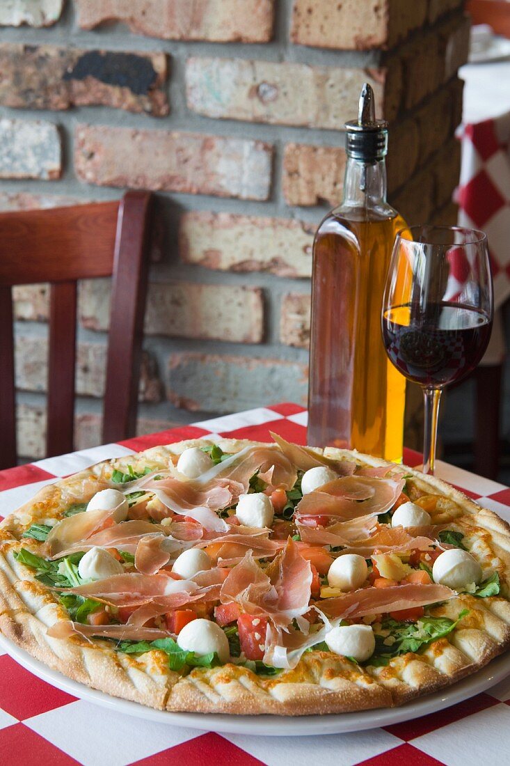 Pizza mit Schinken & Mozzarella auf Restauranttisch