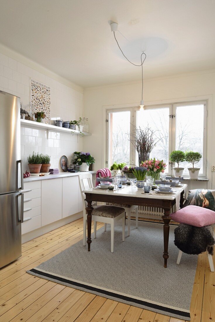 Scandinavian kitchen with vintage dining table and stainless steel fridge