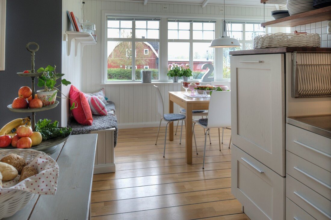 White kitchen-dining room wit oak floor in Swedish wooden house