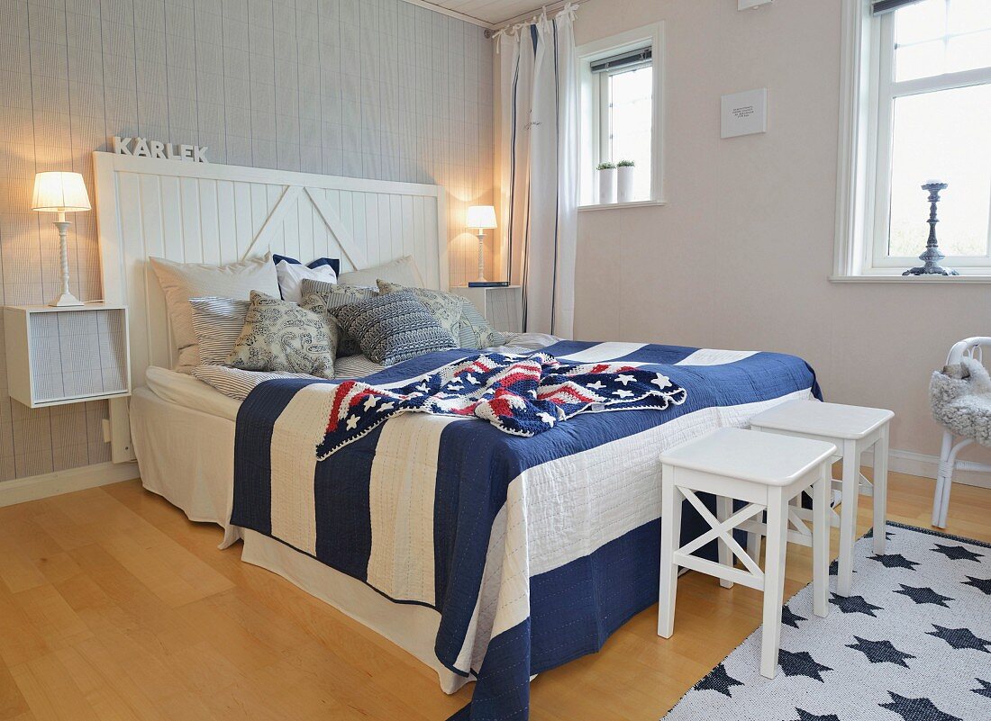 Maritime bedroom with blue and white striped bedspread and crocheted Stars and Stripes blanket on double bed