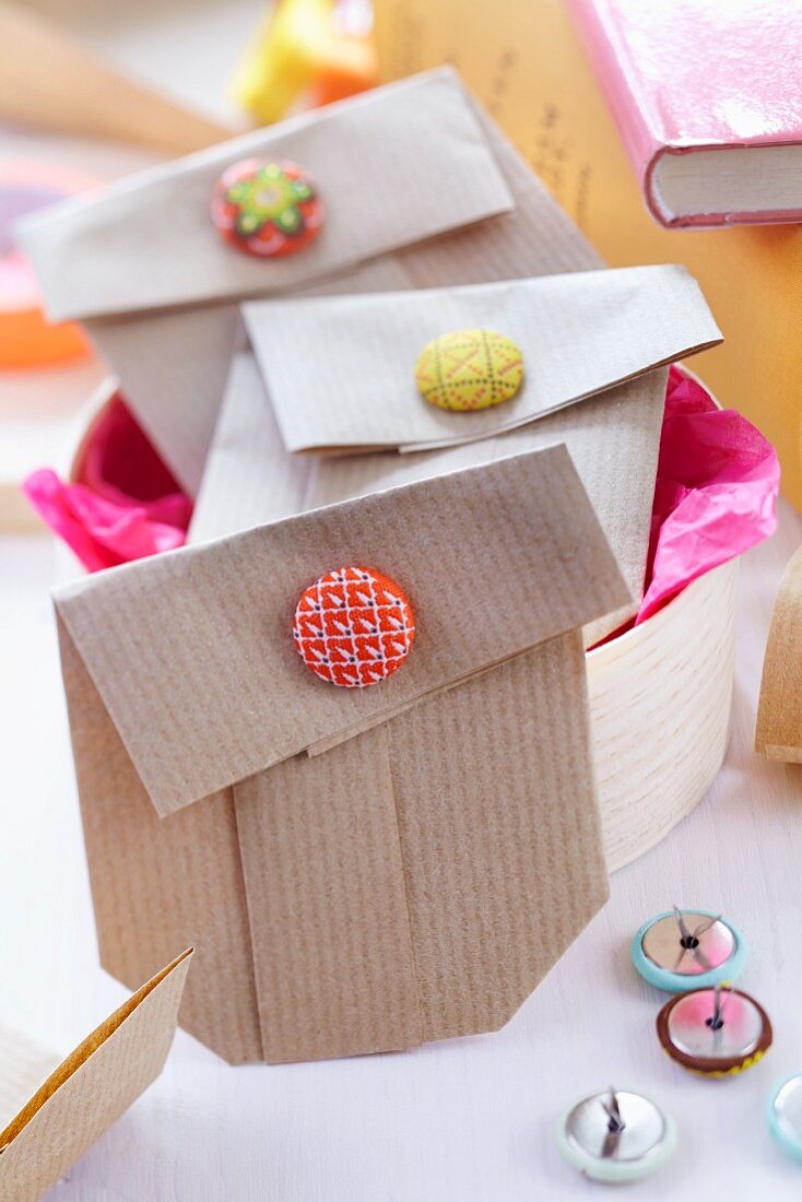 Small gift bags folded from brown paper and held closed with button clips