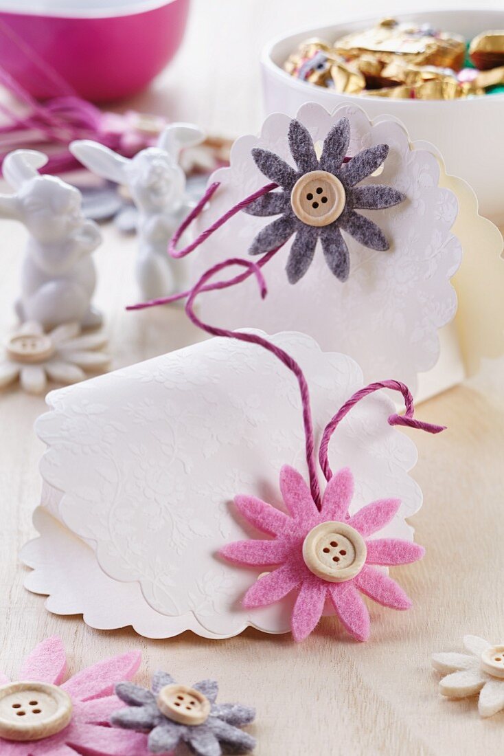 Selbstgemachte Täschchen aus Prägepapier für Ostersüssigkeiten dekoriert mit Filzblüten & Knöpfen
