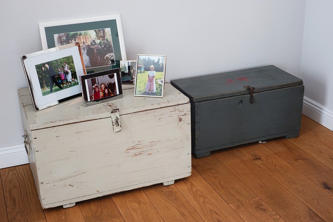 Two wooden trunks with collection of family photos on top of one