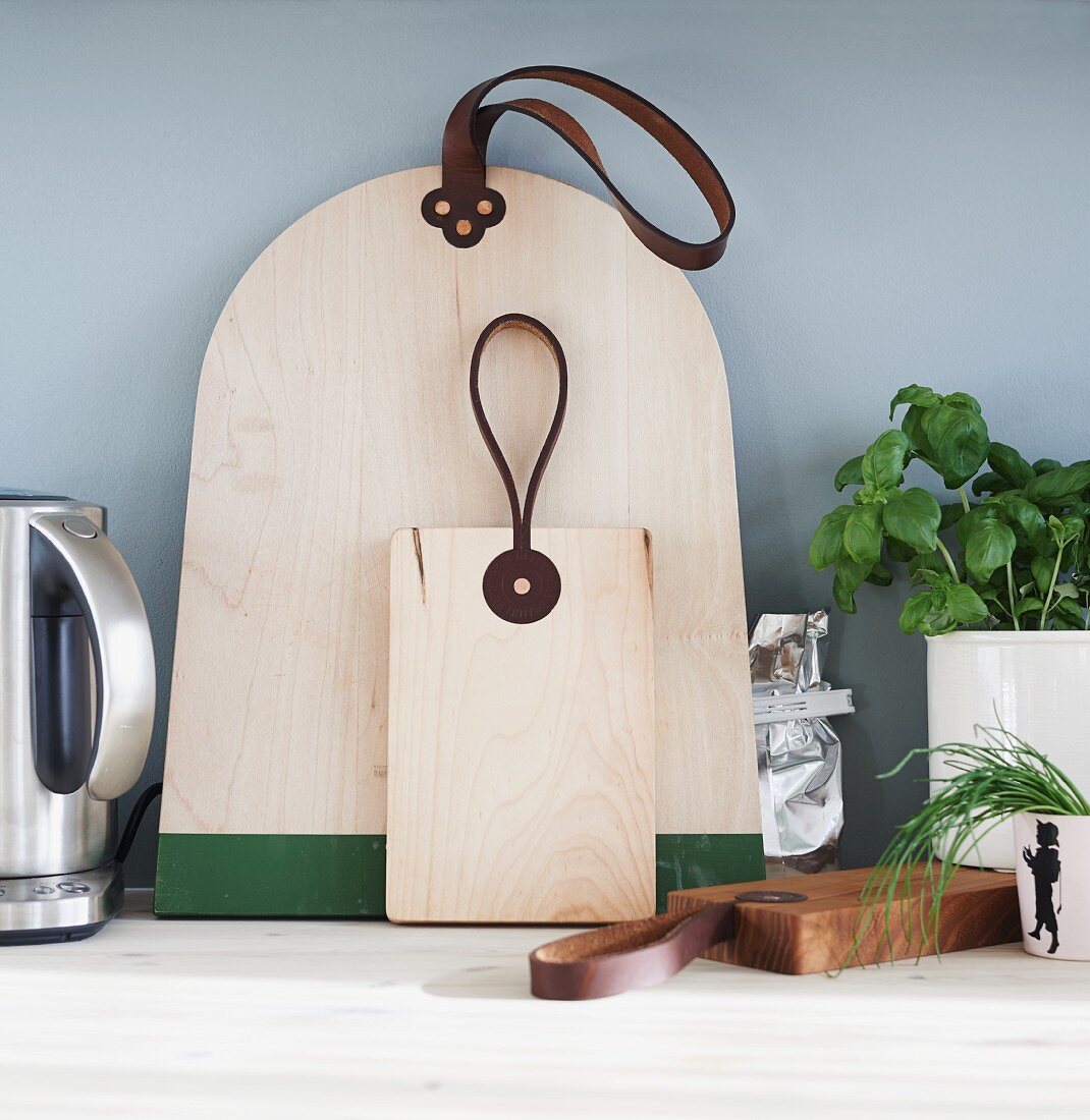 Designer Schneidebretter mit Lederlaschen und Gewürztöpfe auf Küchenarbeitsfläche