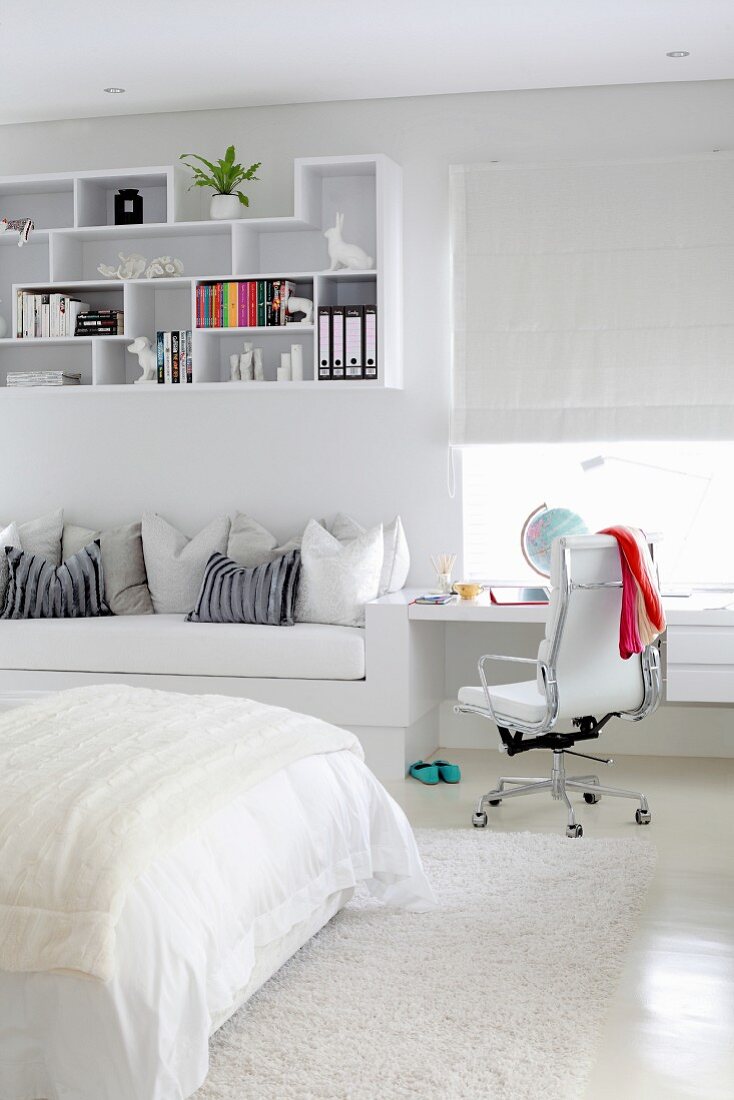 Built-in desk, couch and decorative wall shelves in white, teenager's bedroom