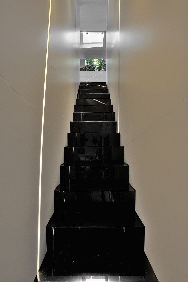 Schmaler Treppenaufgang mit schwarzglänzender Treppe