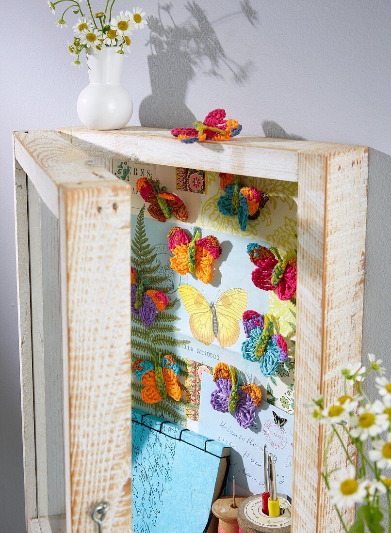 Crocheted butterflies in a display cabinet