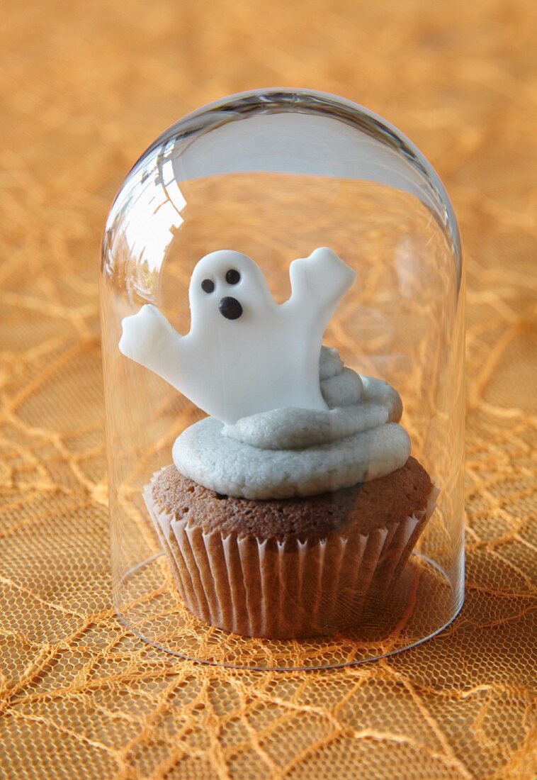 Halloween-Cupcake mit Gespensterdeko unter Glasglocke