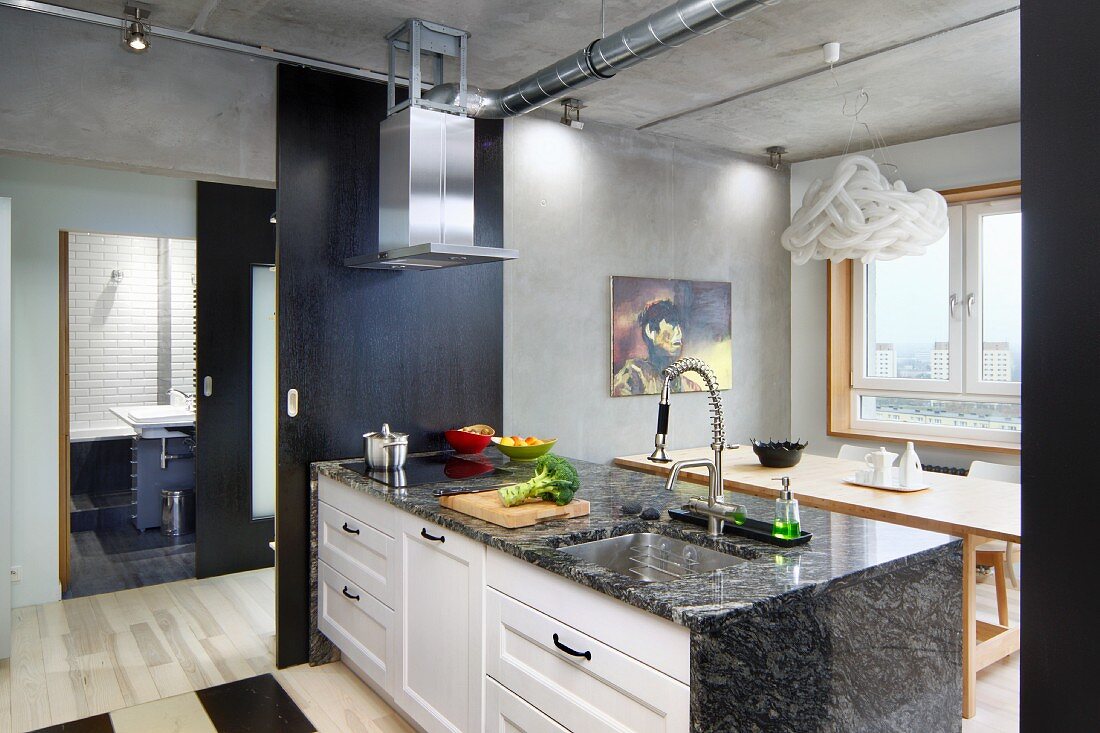 Küchentheke mit Granit-Arbeitsplatte an offener, schwarzer Schiebetür