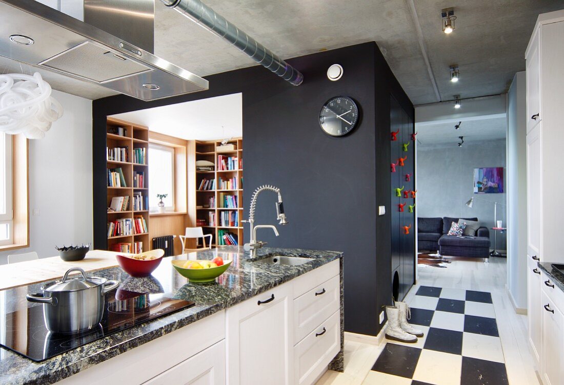 Kitchen counter with granite worksurface in front of office in square installation with black-painted walls