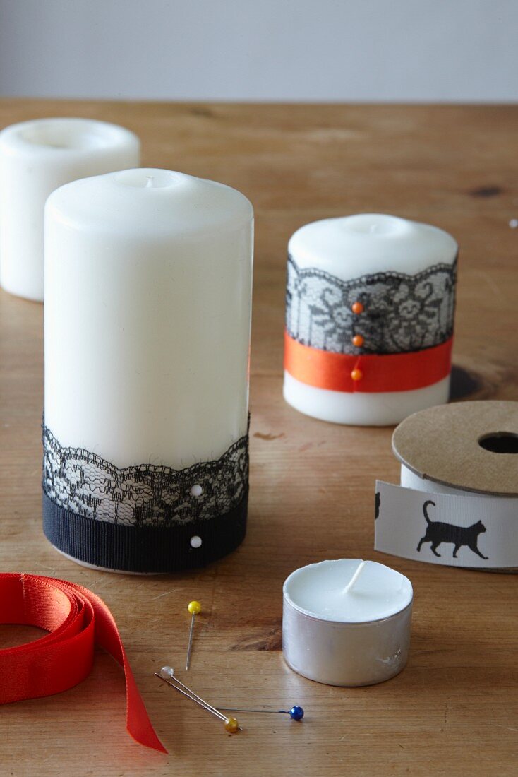 Decorating candles for Halloween using ribbons and trim