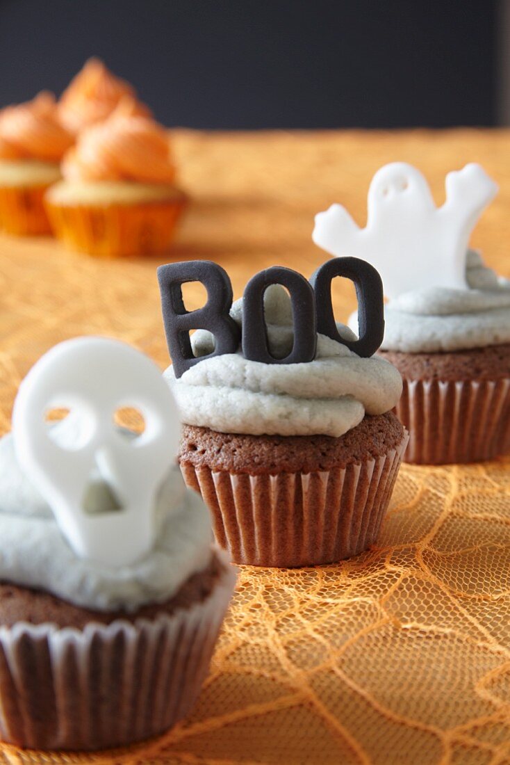Halloween cupcakes decorated with buttercream icing and spooky cake toppers