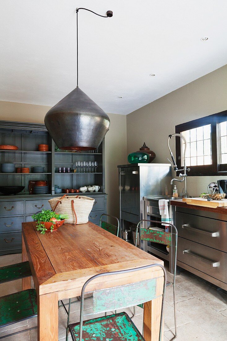 Wooden table and stainless steel cabinets in kitchen with vintage ambiance